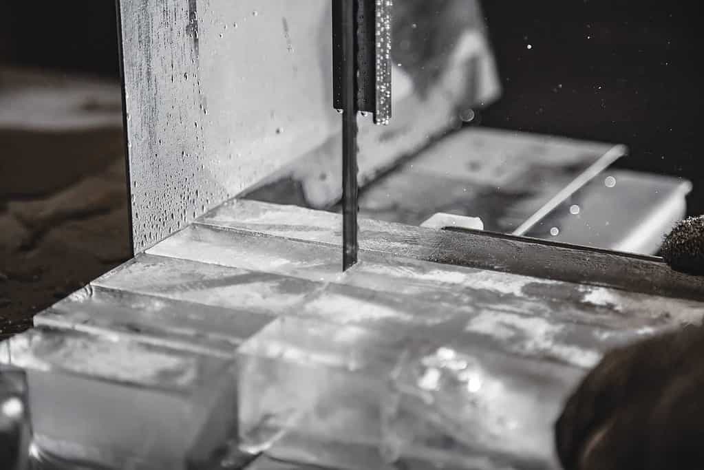 A bandsaw cuts the 300-lb. block of ice into cubes for cocktails.